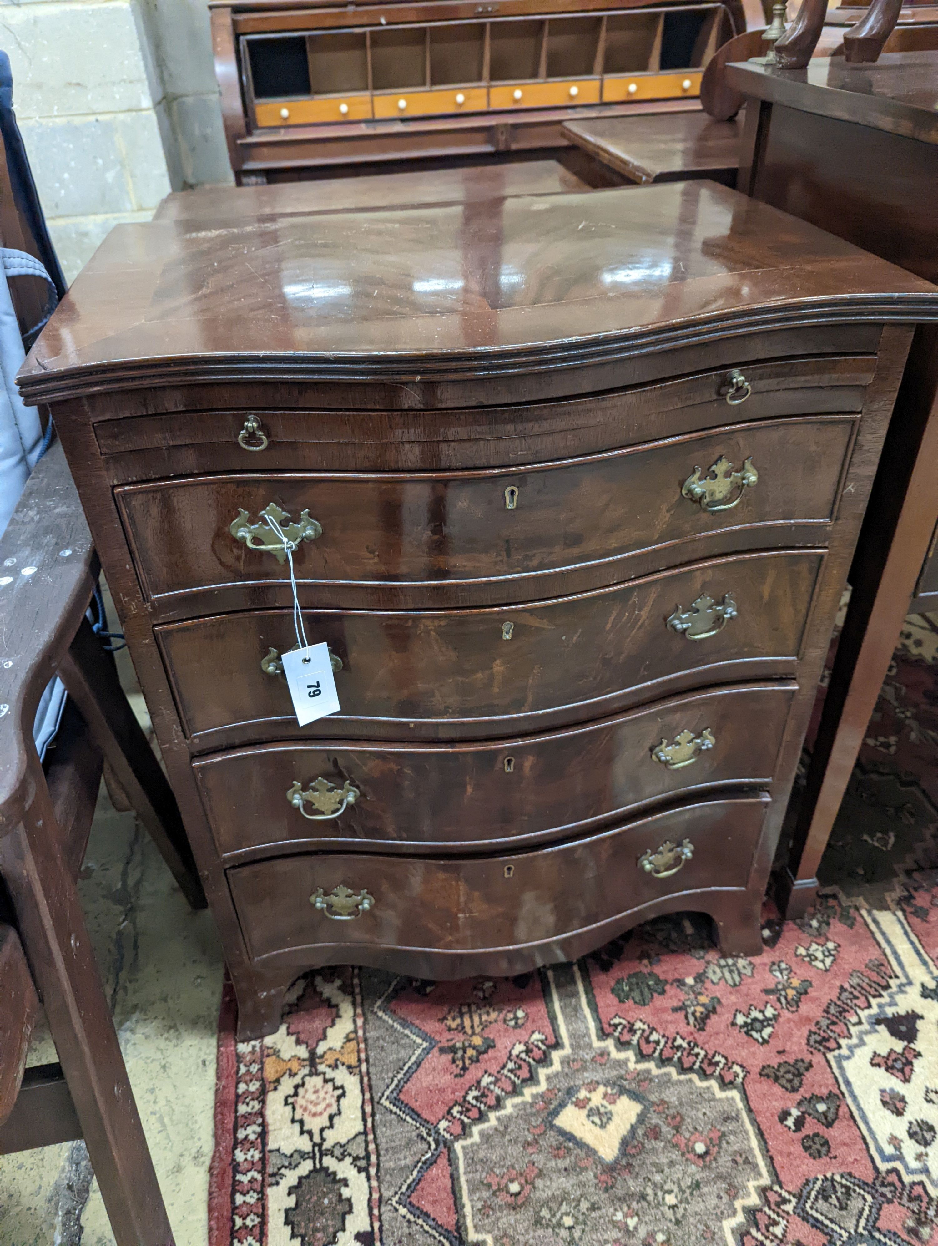 A small reproduction serpentine mahogany chest with slide, width 60cm, depth 44cm, height 77cm